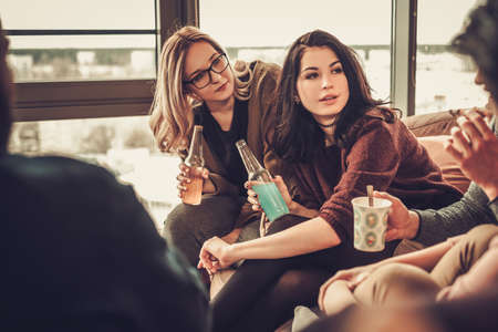 Group of multi ethnic young friends having fun in home interiorの写真素材