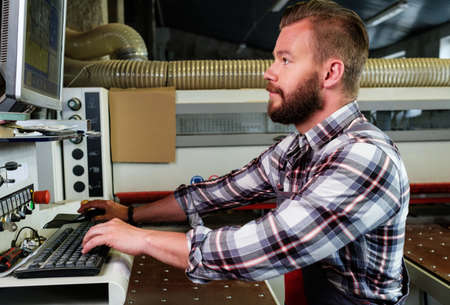 Carpenter doing his job in carpentry workshopの写真素材