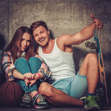 Cheerful couple with with skateboard outdoorsの写真素材