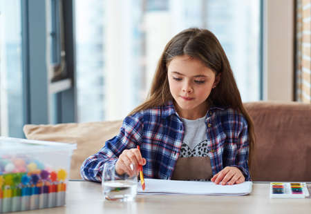 Beautiful little girl painting picture at homeの写真素材