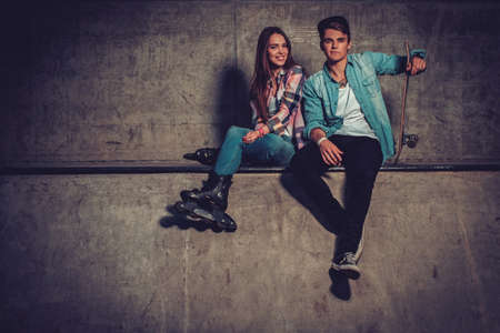 Cheerful couple with with skateboard outdoorsの写真素材