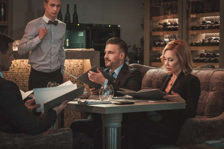 Group of successful business people with menu in restaurantの写真素材