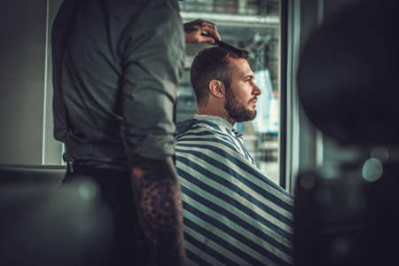 Confident man visiting hairstylist in barber shopの写真素材