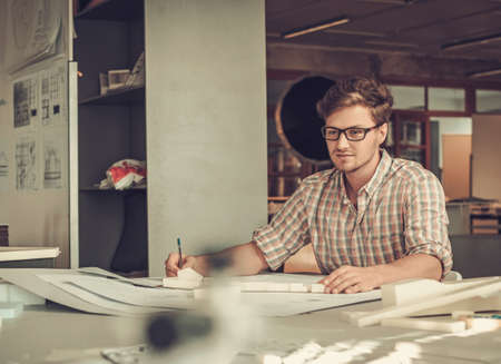 Young architect working in architect studio.