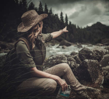 Beautiful woman hiker near wild mountain river.の写真素材