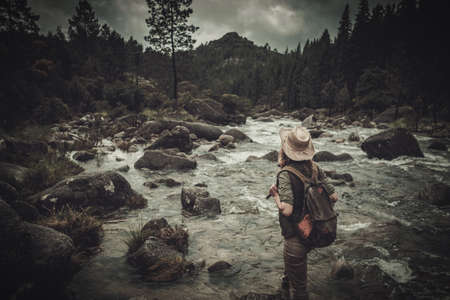 Beautiful woman hiker near wild mountain river.の写真素材
