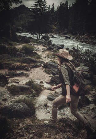 Beautiful woman hiker near wild mountain river.の写真素材