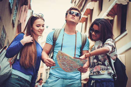 Multi ethnic friends tourists with map in old cityの写真素材