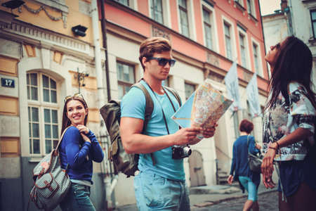 Multi ethnic friends tourists with map in old cityの写真素材