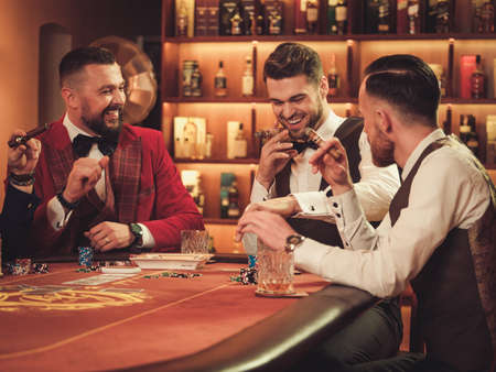 Group of upper class men playing poker in gentlemens club