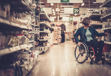 Disabled woman in a wheelchair in a department storeの写真素材