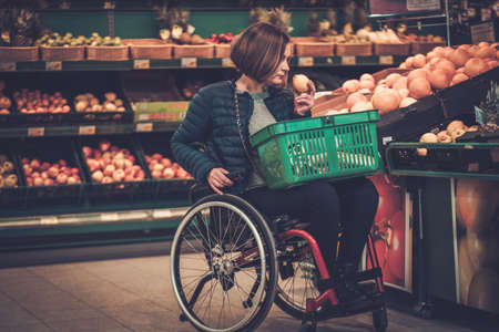 Disabled woman in a wheelchair in a grocery storeの写真素材