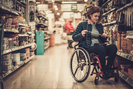 Disabled woman in a wheelchair in a department storeの写真素材