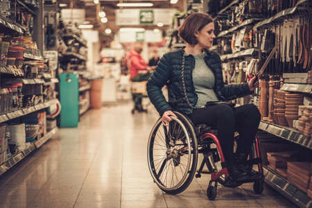 Disabled woman in a wheelchair in a department storeの写真素材