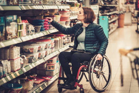 Disabled woman in a wheelchair in a department storeの写真素材