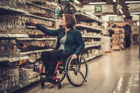 Disabled woman in a wheelchair in a department storeの写真素材