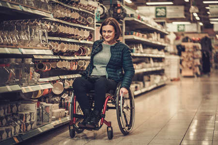 Disabled woman in a wheelchair in a department storeの写真素材
