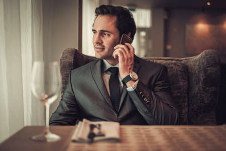 Confident man with smart phone in restaurant.