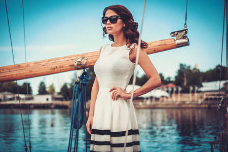 Stylish wealthy woman on a luxury wooden regattaの写真素材