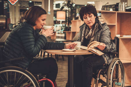 Two physically challenged women in a cafeの写真素材
