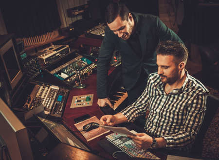 Guys working in boutique recording studioの写真素材