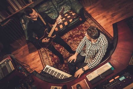 Sound engineer and guitarist working in boutique recording studioの写真素材