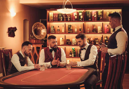 Group of upper class men playing poker in gentlemens clubの写真素材