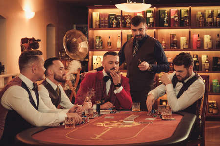 Group of upper class men playing poker in gentlemens club