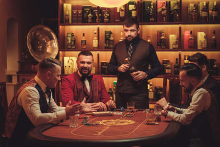 Group of upper class men playing poker in gentlemens club