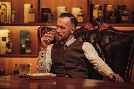 Confident upper class man smoking cigar in gentlemens club