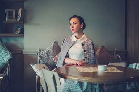 Elegant young lady alone in a cafeの写真素材