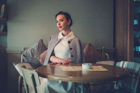Elegant young lady alone in a cafeの写真素材
