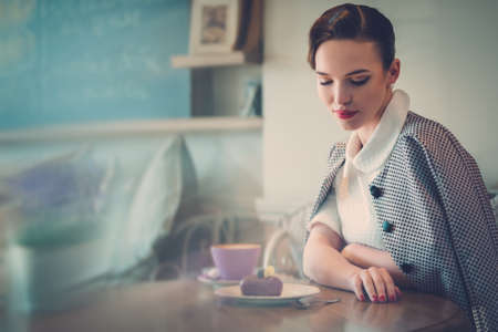 Elegant young lady alone in a cafeの写真素材