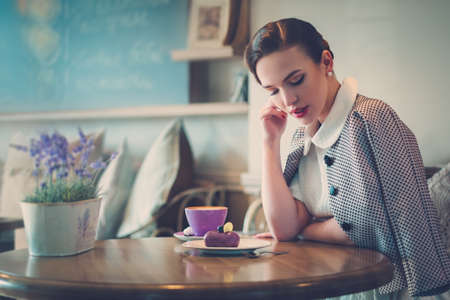 Elegant young lady alone in a cafeの写真素材