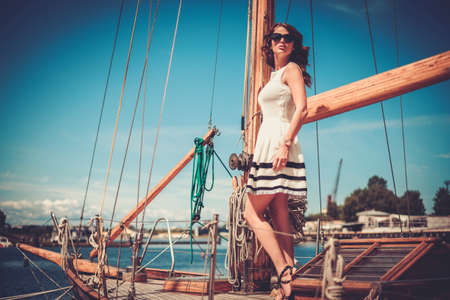 Stylish wealthy woman on a luxury wooden regattaの写真素材