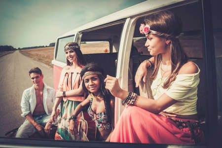 Multi-ethnic hippie friends with guitar on a road tripの写真素材