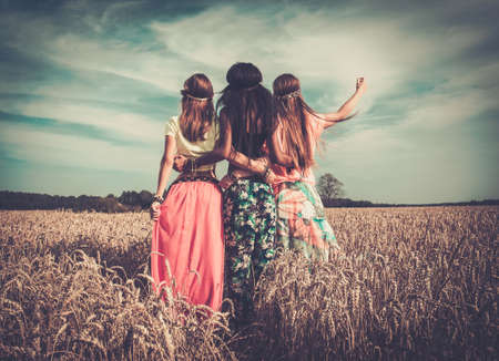 Multi-ethnic hippie girls in a wheat fieldの写真素材