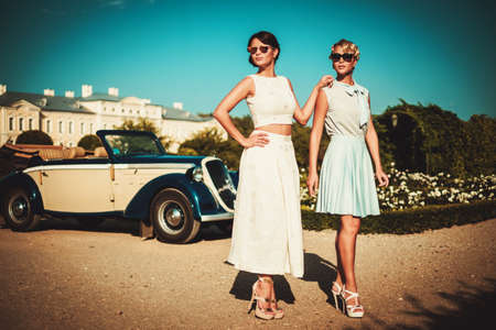 Two stylish ladies near classic convertibleの写真素材