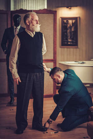 Tailor measuring client for custom made garmentの写真素材