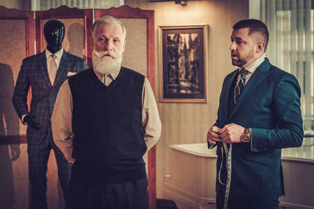 Tailor measuring client for custom made garmentの写真素材