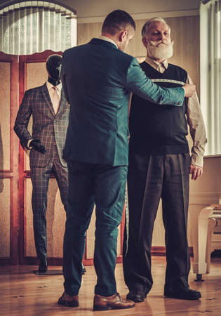 Tailor measuring client for custom made garmentの写真素材