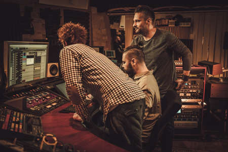 Guys working in boutique recording studioの写真素材