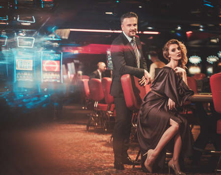 Well-dressed couple against slot machinesの写真素材