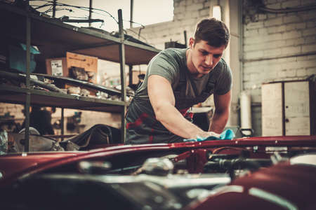 Mechanic polishning car in restoration workshop.の写真素材