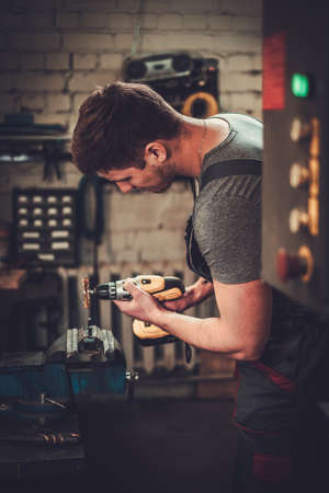 Mechanic working in car repair workshopの写真素材