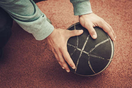 Hands of a man on a basketball ballの写真素材