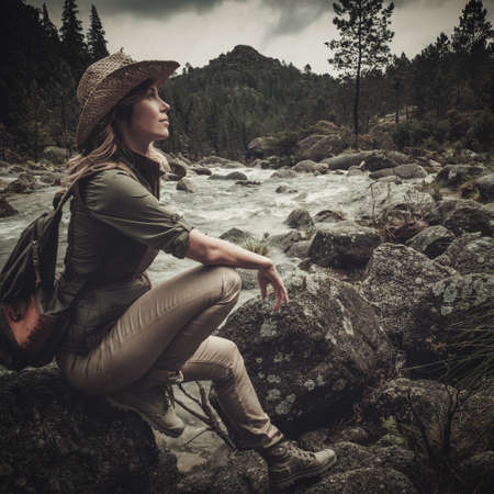 Beautiful woman hiker near wild mountain river.の写真素材