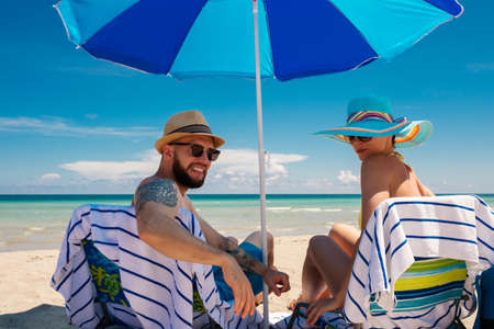 Couple relaxing on a deck chairs on a beach