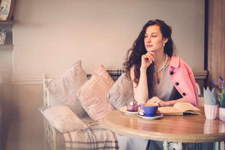 Beautiful lady reading novel in a cafeの写真素材