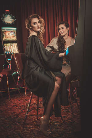 Beautiful women near slots machines in a luxury casino interiorの写真素材
